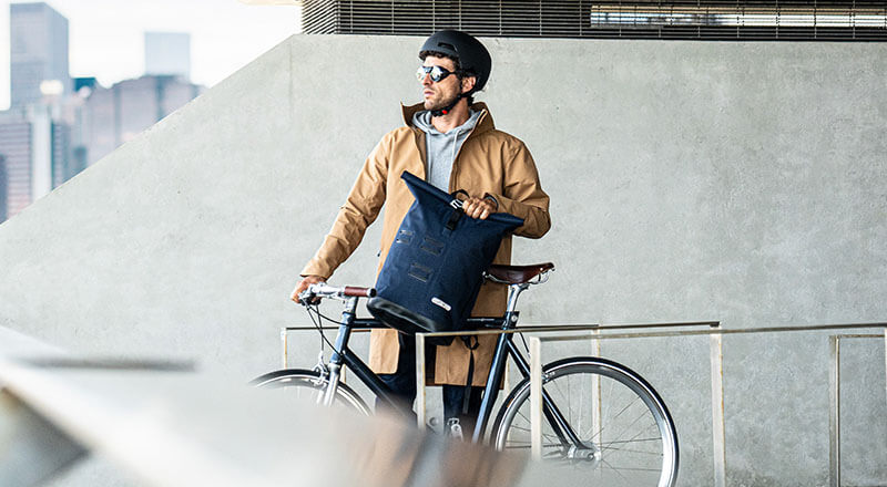 Herr mit Fahrrad und Ortlieb Commuter Daypack in der Stadt
