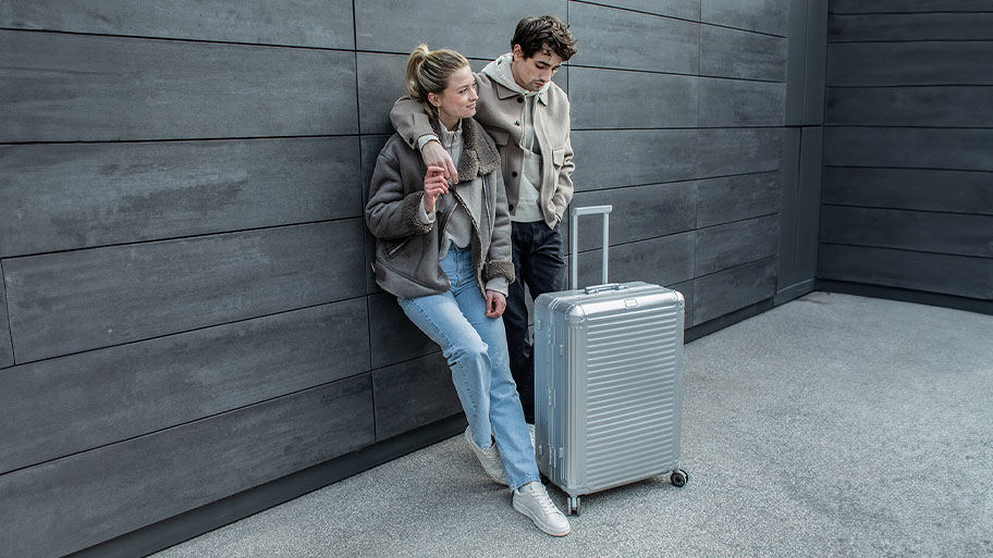 Junges Paar mit silbernem Next Koffer von travelite